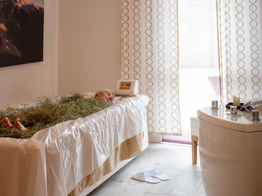 Wellnesshotel im Defereggental: Wohlfühlurlaub vom Feinsten Frau entspannt in Heubad im Wellnessraum mit Tageslicht