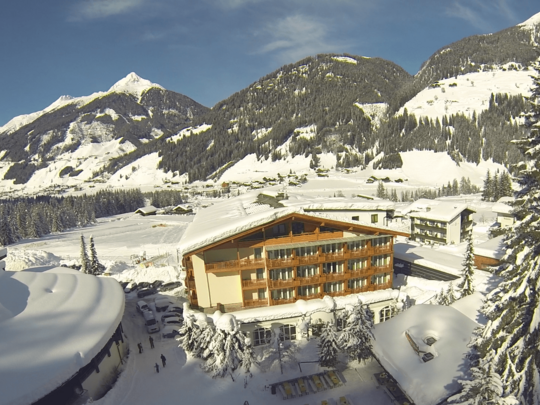 A hiking hotel in East Tyrol with heart and soul Snow-covered hotel in the mountains under a blue sky