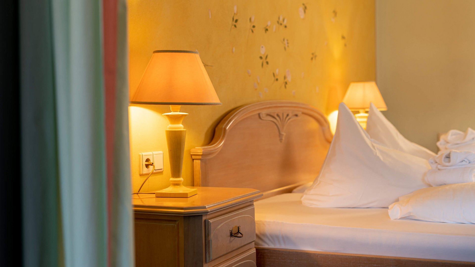 Our family hotel in Tyrol with a 4-star superior rating Cozy bedroom with wooden furniture and warm lighting