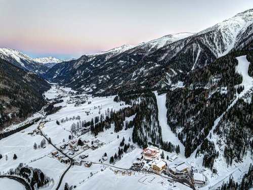 Jesacherhof: Ihre Unterkunft im Defereggental Verschneites Alpental mit Dörfern, Wald und Bergen bei Sonnenuntergang