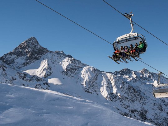 Jesacherhof: Ihr Hotel im Defereggental Skilift mit Skifahrern vor schneebedeckten Bergen und klarem Himmel