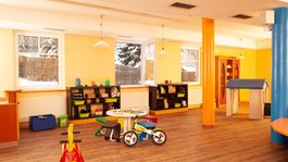 I servizi del nostro hotel per famiglie in Tirolo Angolo giochi colorato per bambini con giocattoli e tavoli colorati