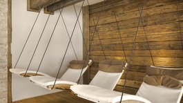 I servizi del nostro hotel per famiglie in Tirolo Sedie a dondolo con cuscini in una stanza accogliente con rivestimento in legno