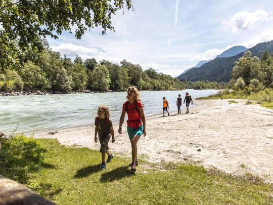 Jesacherhof: Ihr Hotel im Defereggental Familie wandert am Flussufer entlang in einer bergigen Landschaft