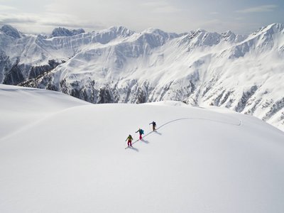 I tour di scialpinismo più belli del Tirolo Orientale Tre sciatori attraversano neve fresca intatta sulle montagne