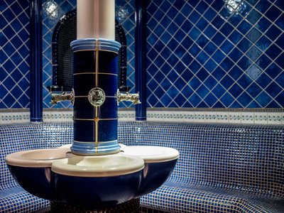 Area adults only del nostro wellness hotel in Austria Interno di bagno di vapore tradizionale con piastrelle blu e fontana d'acqua