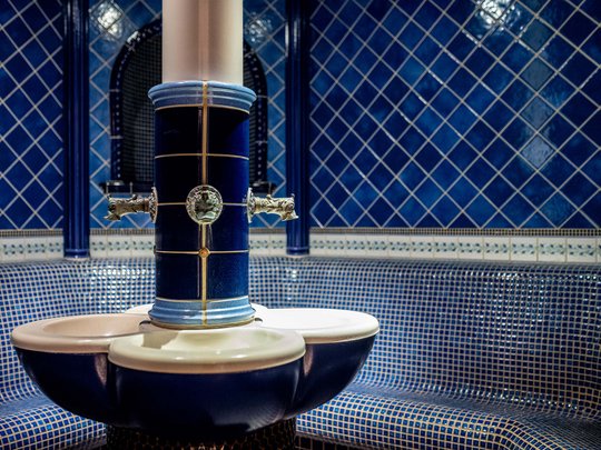 Wellnesshotel im Defereggental: Wohlfühlurlaub vom Feinsten Blau geflieste Innenansicht eines traditionellen Dampfbads mit Wasserbrunnen