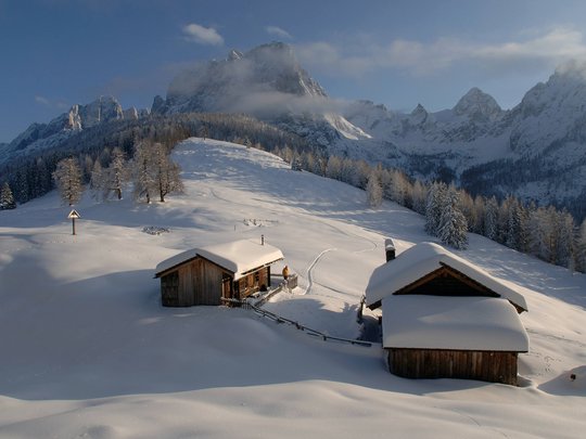 Ausflugsziele im Defereggental Verschneite Berghütten mit Bergen und Bäumen im Winter