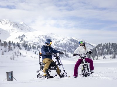 Unvergesslicher Skiurlaub im Defereggental Zwei Personen fahren Schneemobile auf verschneitem Bergplateau