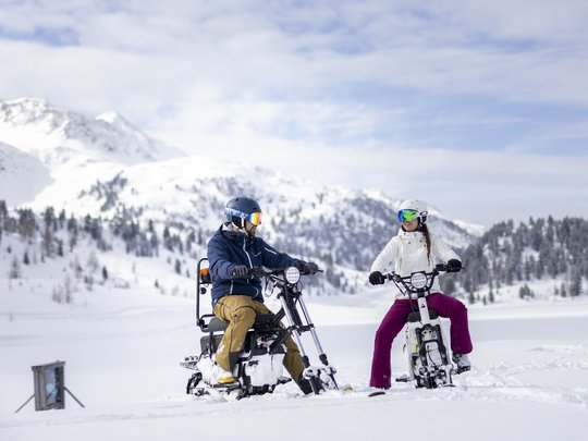 Jesacherhof: Ihr Hotel im Defereggental Zwei Personen fahren Schneemobile auf verschneitem Bergplateau