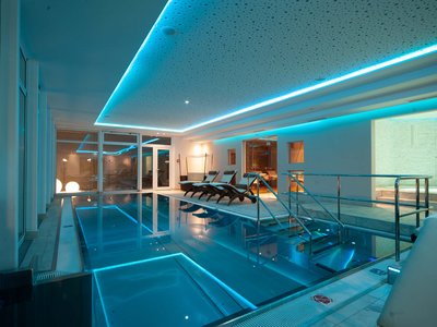 Wellnesshotel im Defereggental: Wohlfühlurlaub vom Feinsten Moderner Innenpool mit blauem LED-Licht und Liegestühlen