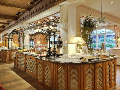 Benessere alpino al nostro albergo in Tirolo Ristorante luminoso con buffet in legno e cornice decorativa in ferro