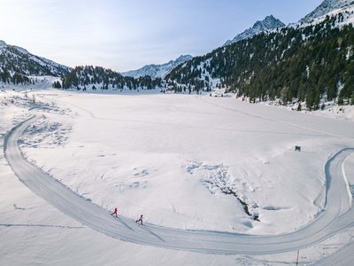Unvergesslicher Skiurlaub im Defereggental Zwei Langläufer auf verschneiter Piste in winterlicher Berglandschaft