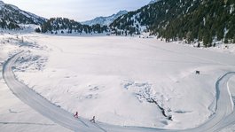I servizi del nostro hotel per famiglie in Tirolo Due sciatori di fondo su pista innevata in paesaggio montano invernale