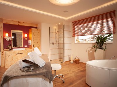 Day spa in East Tyrol Cozy spa room with massage table, bathtub, and shower