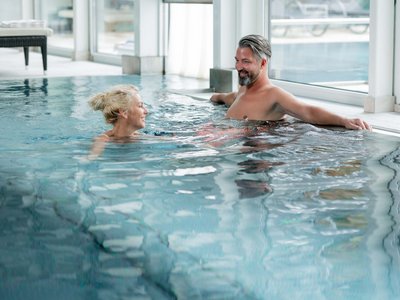 Area adults only del nostro wellness hotel in Austria Coppia che si rilassa nella piscina coperta e conversa