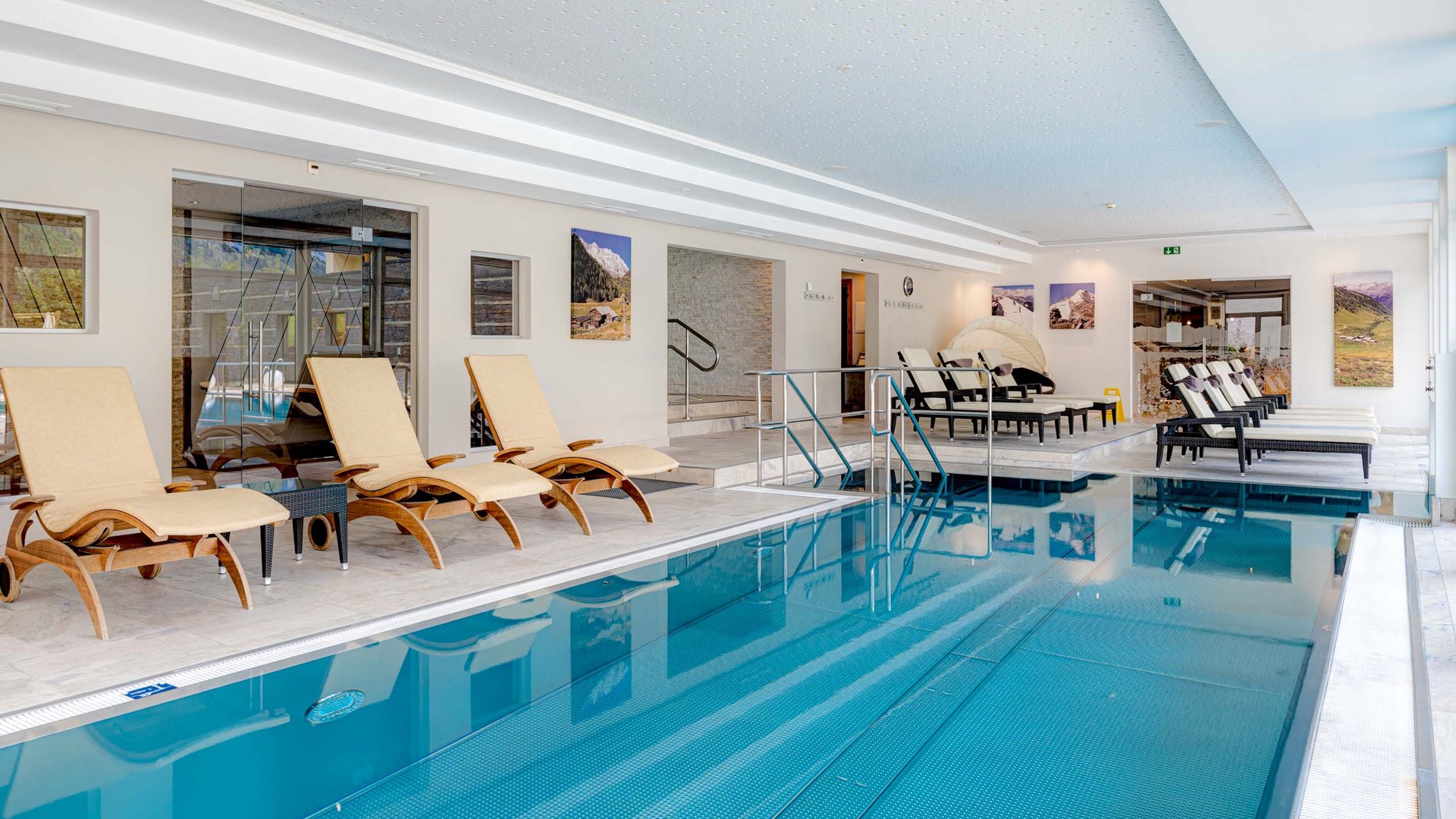 I servizi del nostro hotel per famiglie in Tirolo Piscina coperta con lettini e quadri alle pareti
