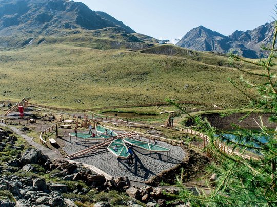 Ausflugsziele im Defereggental Kinder spielen an Wasserspielen im Bergspielplatz mit Alpen im Hintergrund