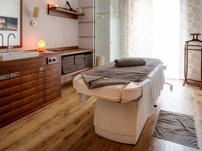 Family hotel in East Tyrol: the Jesacherhof Cozy massage room with table and wooden furniture in warm atmosphere