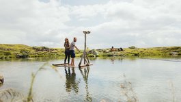 I servizi del nostro hotel per famiglie in Tirolo Coppia su zattera di legno in lago tranquillo in ambiente rurale