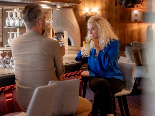 Jesacherhof: Gourmethotel in Österreich Paar sitzt an Bar und trinkt Cocktails in gemütlicher Bar
