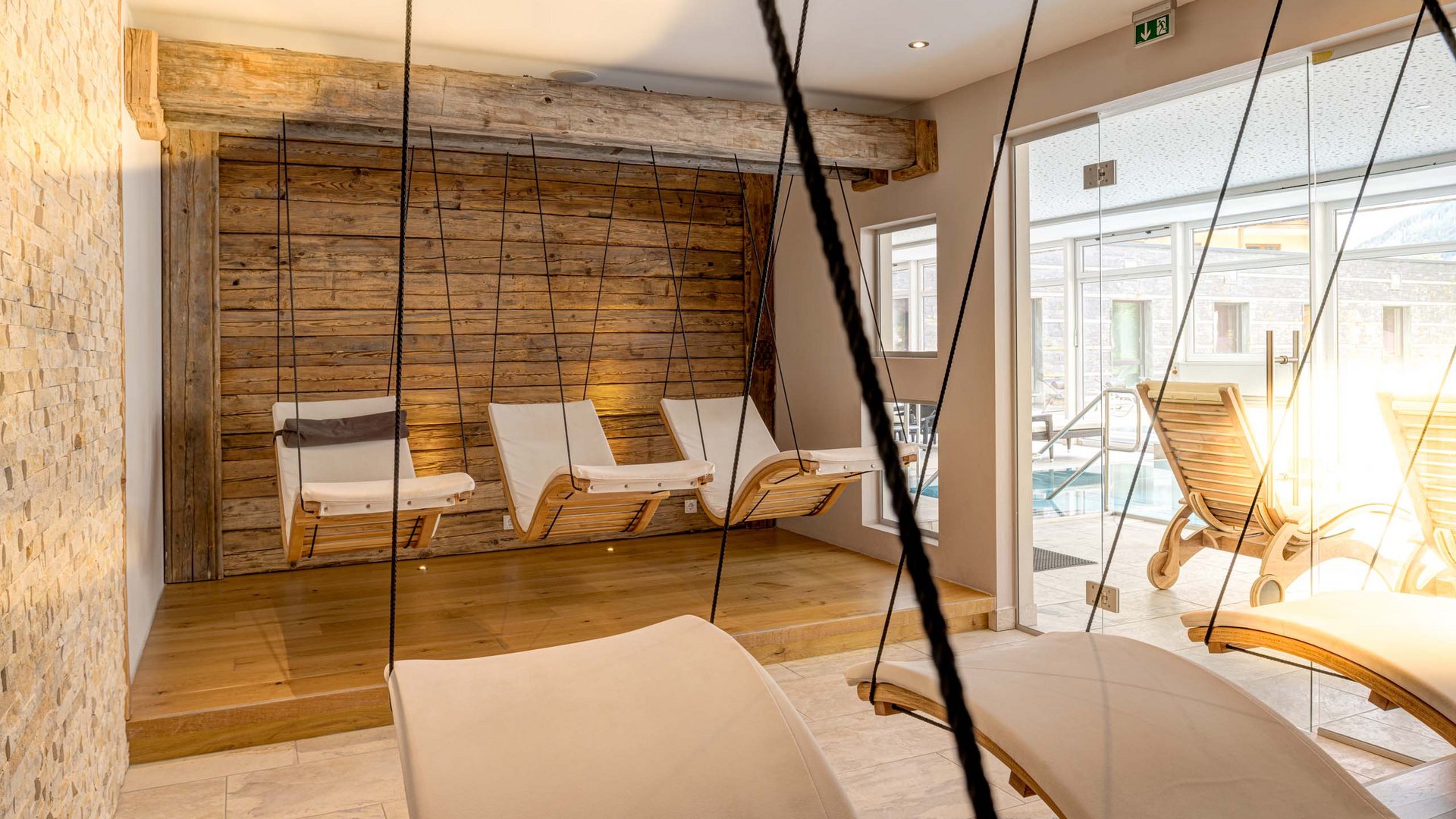 I servizi del nostro hotel per famiglie in Tirolo Sedie a dondolo sospese e lettini in una spa luminosa e tranquilla