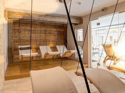 Area adults only del nostro wellness hotel in Austria Sedie a dondolo sospese e lettini in una spa luminosa e tranquilla