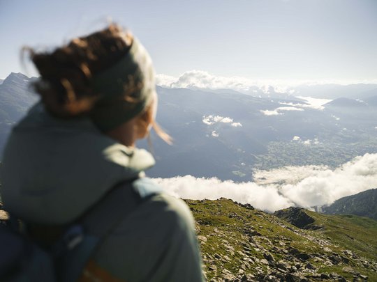 Ausflugsziele im Defereggental Person blickt auf ein nebliges Tal und Berge bei klarem Himmel