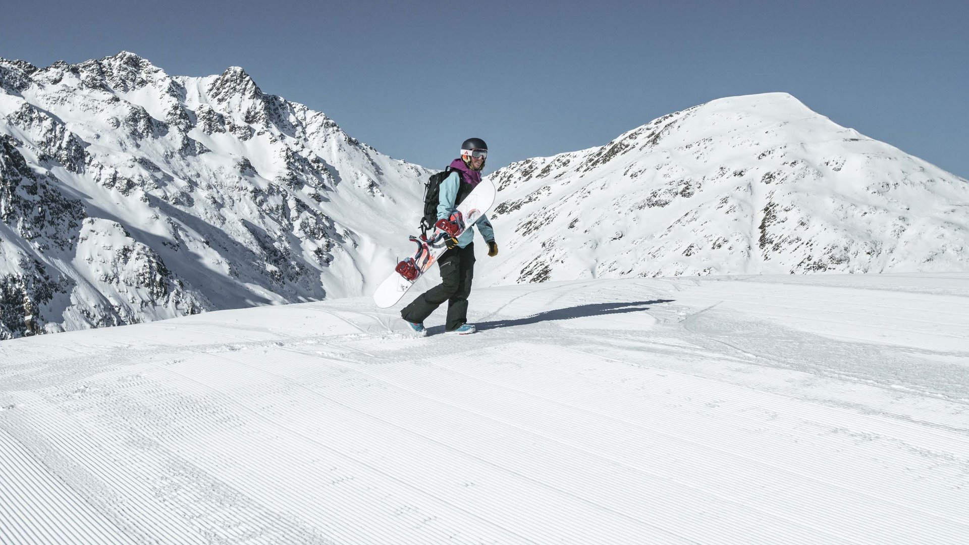 Unvergesslicher Skiurlaub im Defereggental Snowboarder geht auf präparierter Piste mit schneebedeckten Bergen im Hintergrund