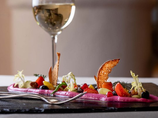 Jesacherhof: Gourmethotel in Österreich Fein angerichtete Gourmet-Vorspeise mit Weißwein im Glas
