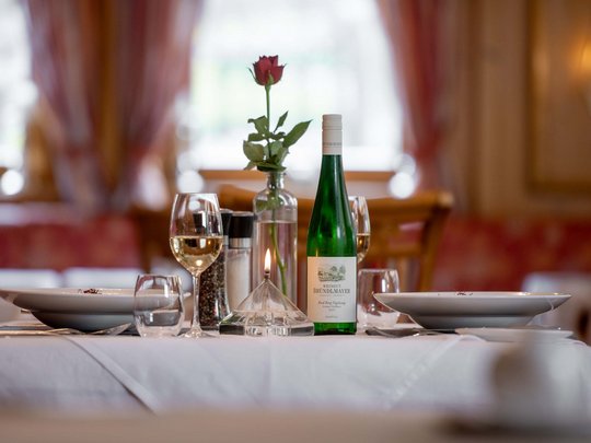 Jesacherhof: Gourmethotel in Österreich Eleganter gedeckter Tisch mit Wein, Kerze und Rose in Restaurant