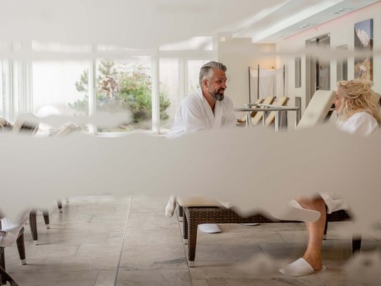 Wellnesshotel im Defereggental: Wohlfühlurlaub vom Feinsten Paar entspannt in Bademänteln in einem hellen Wellnessbereich