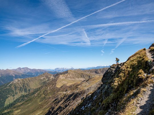 Trekking in Tirolo, Austria: allo Jesacherhof Escursionisti su sentiero di montagna con panorama alpino e cielo limpido