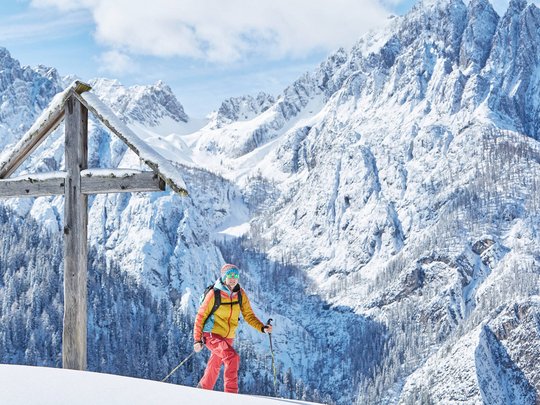 St. Jakob in Defereggen: escursioni e gite Sciatore accanto a grande croce di legno sulle montagne innevate