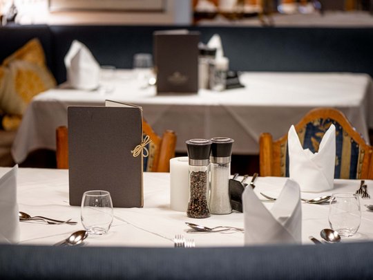 Jesacherhof: Gourmethotel in Österreich Eleganter gedeckter Tisch im Restaurant mit Menükarten und Gewürzstreuern