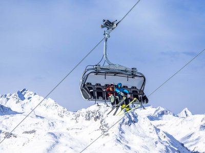 Sciare in Austria: sogno innevato Due sciatori su una seggiovia sopra montagne innevate