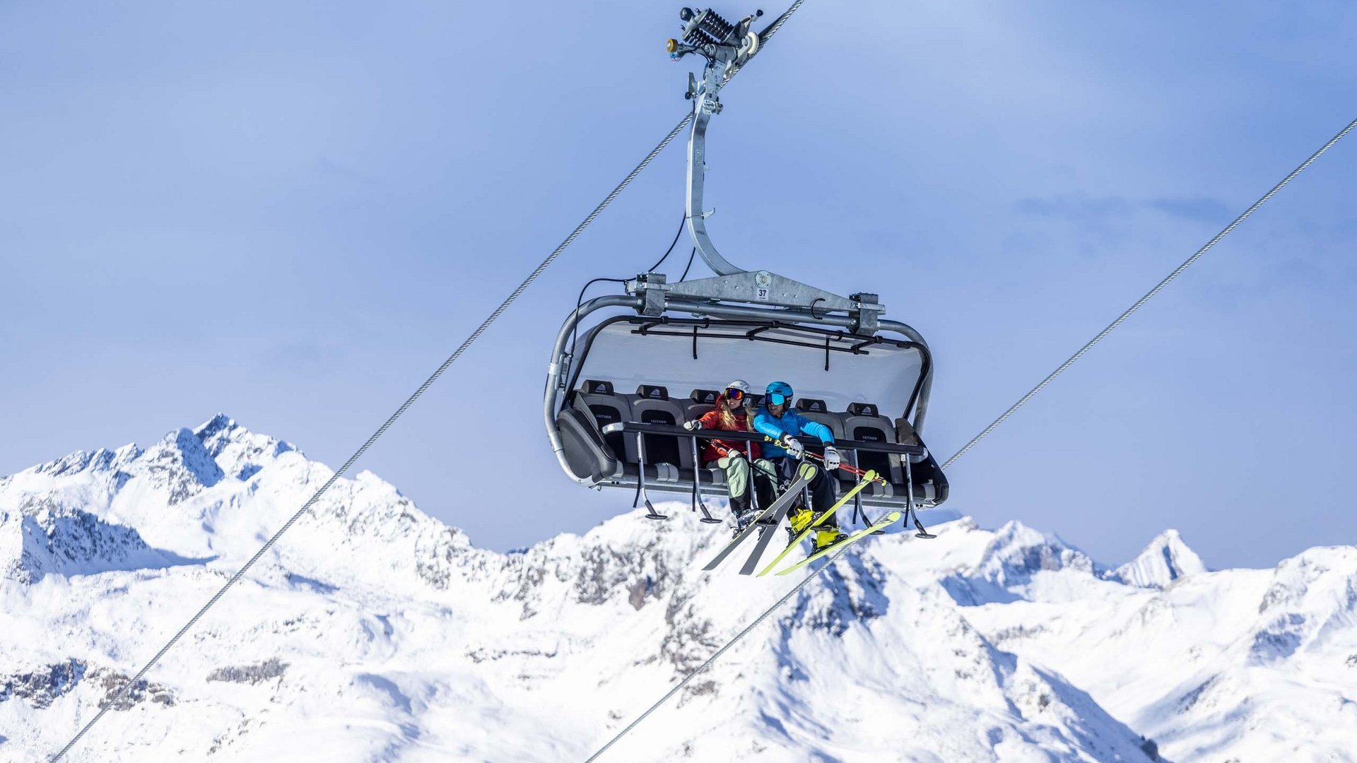 Unvergesslicher Skiurlaub im Defereggental Zwei Skifahrer auf einem Sessellift über schneebedeckten Bergen