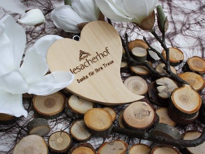 Our family hotel in Tyrol with a 4-star superior rating Wooden heart with text on wood slices and white flowers
