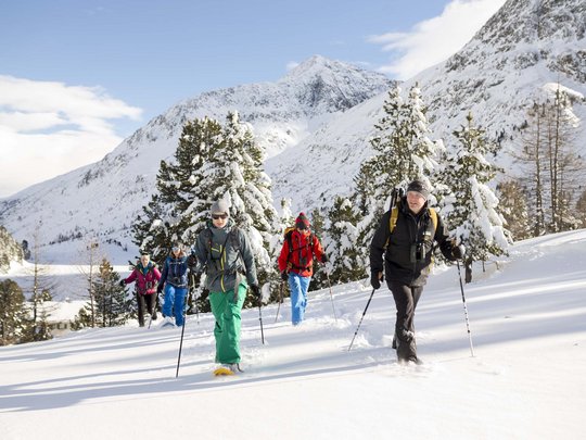 Jesacherhof: Ihr Hotel im Defereggental Gruppe beim Schneeschuhwandern in verschneiter Berglandschaft bei Sonnenschein