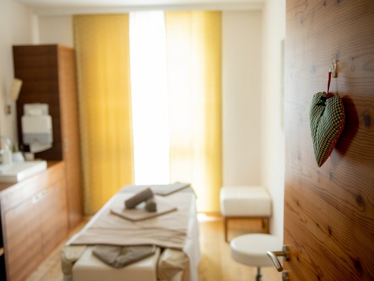 Day spa in East Tyrol Bright massage room with wooden door and heart decoration