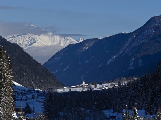 St. Jakob in Defereggen: escursioni e gite Valle innevata con chiesa tra montagne boscose e cime innevate