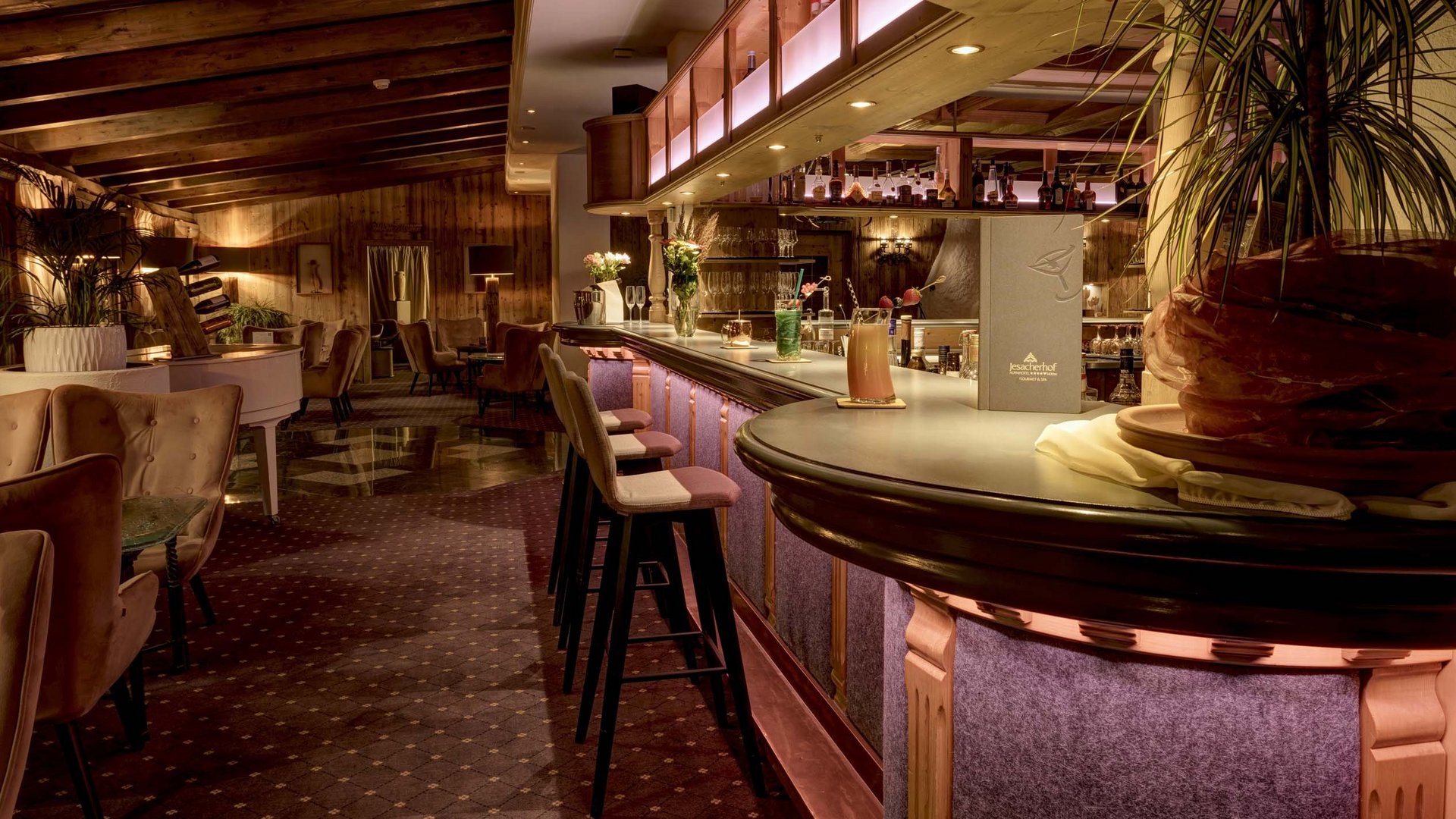 Benessere alpino al nostro albergo in Tirolo Bar dell'hotel accogliente con pannelli in legno e illuminazione a LED
