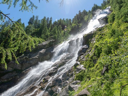 Defereggental: Sehenswürdigkeiten und Ausflugsziele Wasserfall in grünem Wald unter strahlender Sonne
