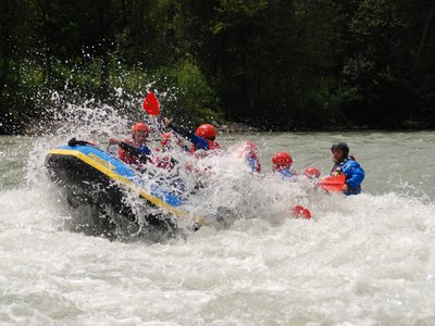 Rafting in Austria, spumeggiante divertimento Persone che fanno rafting con caschi rossi e pagaie