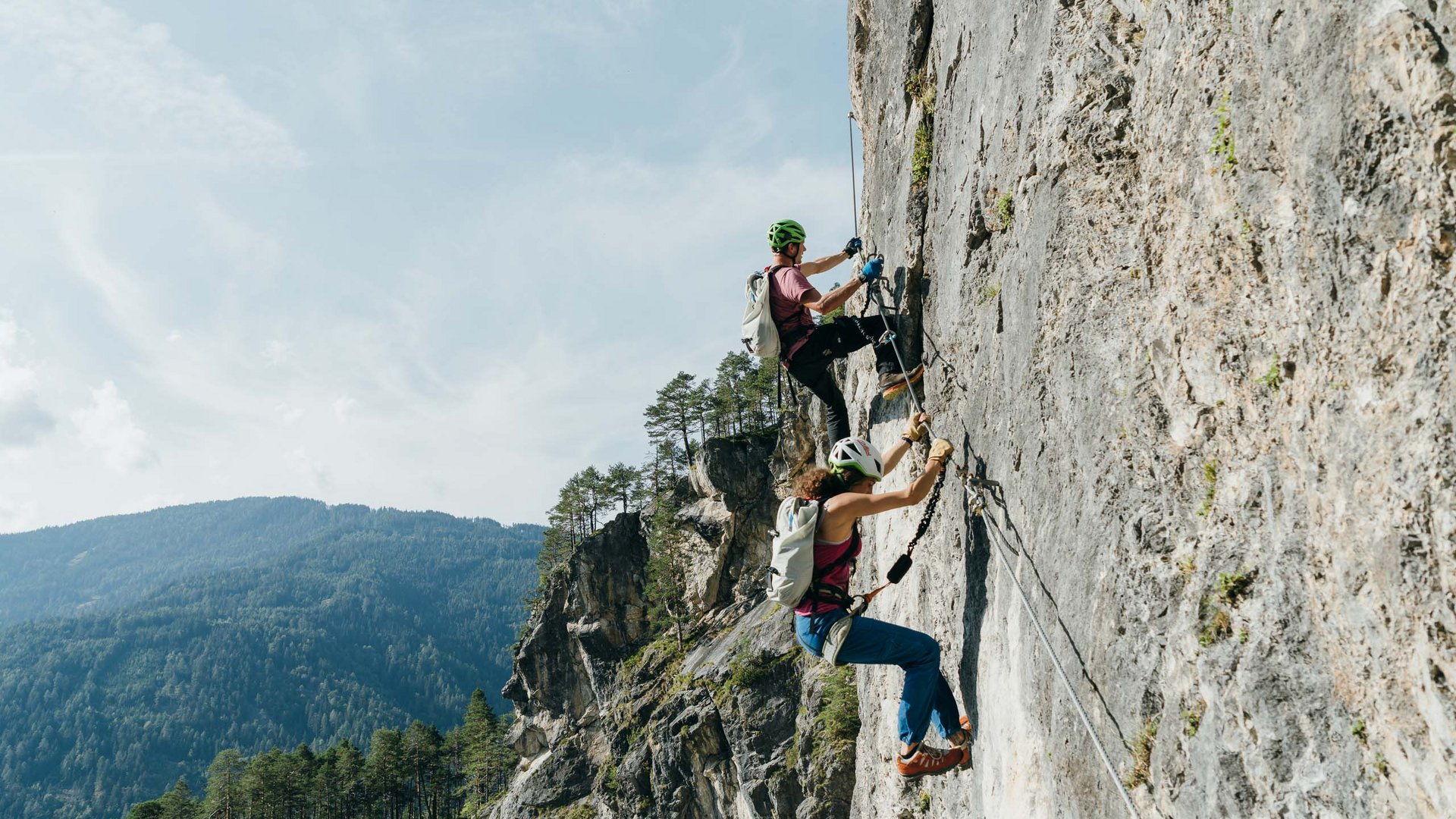 Unvergesslicher Skiurlaub im Defereggental Zwei Kletterer in Helmen erklimmen eine Felswand mit Sicherungsseilen